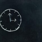 Mit Kreide gezeichnete Uhr auf Tafel