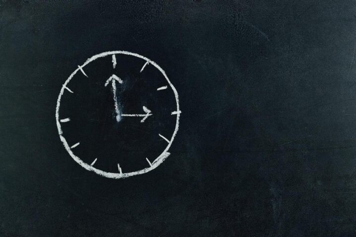 Mit Kreide gezeichnete Uhr auf Tafel