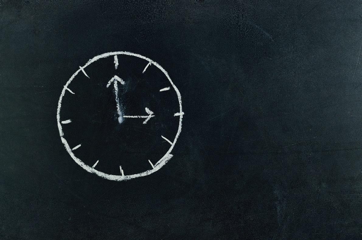 Mit Kreide gezeichnete Uhr auf Tafel